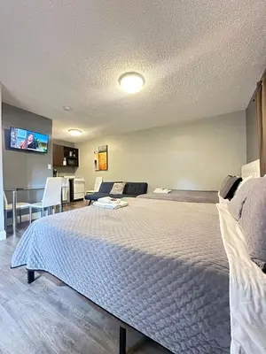 a bedroom with a large bed and a tv at Sheridan Guesthouse in Dania Beach
