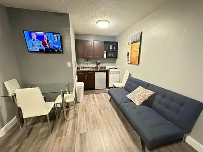 a living room with a blue couch and a kitchen at Sheridan Guesthouse in Dania Beach