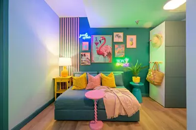 a childs room with a green couch and a pink stool at Barbizon on Ocean Drive Apartments in Miami Beach