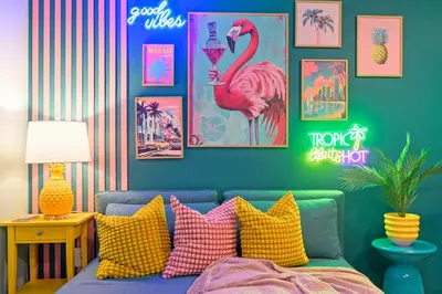 a living room with a blue couch with colorful pillows at Barbizon on Ocean Drive Apartments in Miami Beach