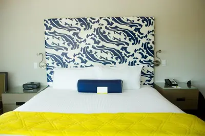 a bedroom with a bed with a blue and white wallpaper at Hotel Breakwater South Beach in Miami Beach