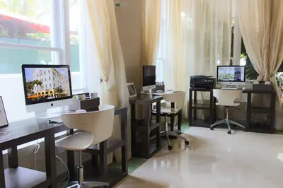 a room with three desks with computers and chairs at Hotel Breakwater South Beach in Miami Beach