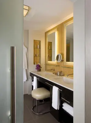 a bathroom with a large sink and a stool at Hotel Breakwater South Beach in Miami Beach