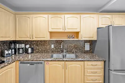 a kitchen with wooden cabinets and a sink and a refrigerator at THE TIDES 1 bedroom apt 8th floor WE ARE ON THE BEACH in Hollywood