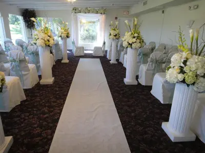 a row of white vases with flowers in a room at Grand Palms Spa & Golf Resort in Pembroke Pines