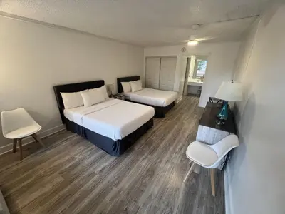 a room with two beds and a table and chairs at Grand Palms Spa & Golf Resort in Pembroke Pines