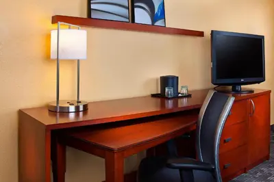 a desk with a computer monitor and a chair at Courtyard Miami Airport West Doral in Miami