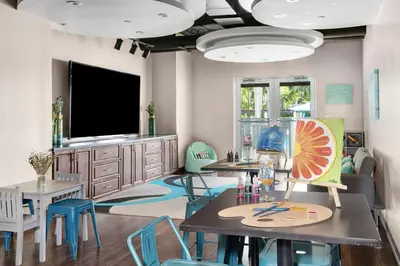 a living room with tables and chairs and a flat screen tv at Marriott's Villas At Doral in Miami
