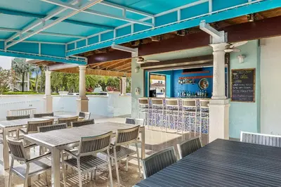 a patio with tables and chairs and a bar at Marriott's Villas At Doral in Miami