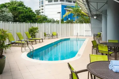 a pool with tables and chairs next to a building at SpringHill Suites Miami Downtown/Medical Center in Miami