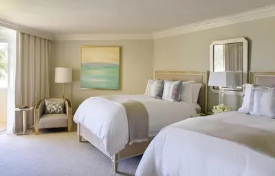 a hotel room with two beds and a chair at Trump National Doral Golf Resort in Miami