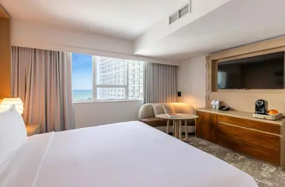 a hotel room with a bed and a large window at Eden Roc Miami Beach in Miami Beach