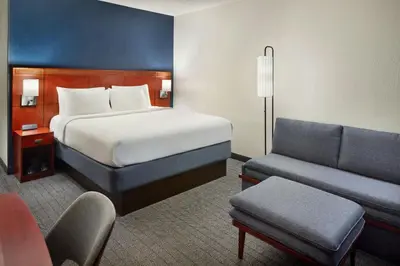 a hotel room with a bed and a couch at Courtyard by Marriott Fort Lauderdale City of Plantation in Plantation