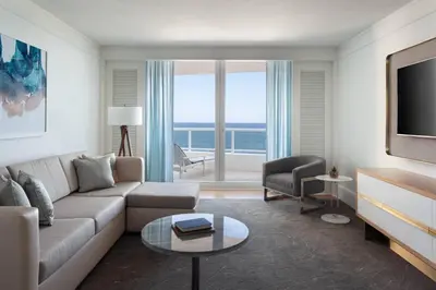 a living room with a couch and a tv at The Ritz-Carlton, Fort Lauderdale in Fort Lauderdale