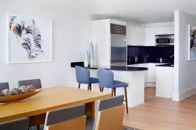 a kitchen and dining room with a wooden table and blue chairs at The Ritz-Carlton, Fort Lauderdale in Fort Lauderdale
