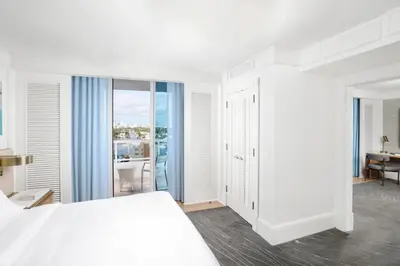 a white bedroom with a bed and a desk at The Ritz-Carlton, Fort Lauderdale in Fort Lauderdale