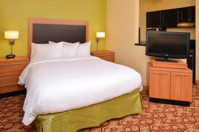 a bedroom with a large bed and a television at Candlewood Suites Miami Lakes by IHG in Miami Lakes