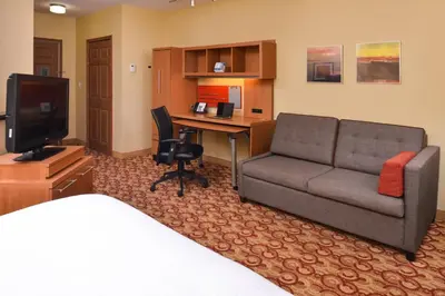 a hotel room with a couch and a desk at Candlewood Suites Miami Lakes by IHG in Miami Lakes