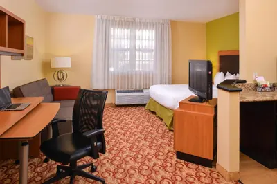 a hotel room with a bed and a desk and a television at Candlewood Suites Miami Lakes by IHG in Miami Lakes