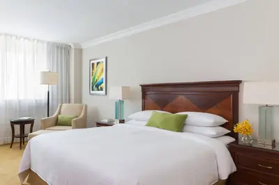 a bedroom with a large white bed and a chair at JW Marriott Miami in Miami