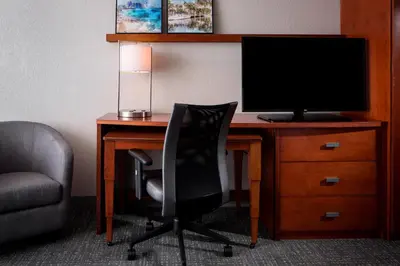 a desk with a computer monitor and a chair at Courtyard by Marriott Fort Lauderdale Airport & Cruise Port in Dania Beach