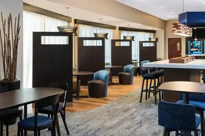 a dining room with tables and blue chairs at Courtyard by Marriott Fort Lauderdale Airport & Cruise Port in Dania Beach