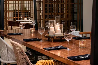 a wooden table with wine glasses and candles on it at Renaissance Fort Lauderdale Cruise Port Hotel in Fort Lauderdale