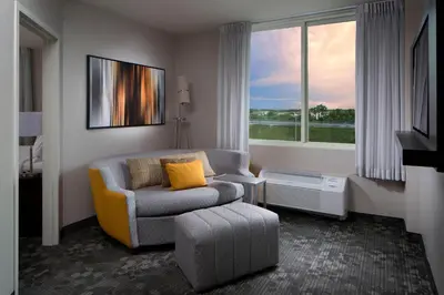a living room with a couch and a chair and a window at Courtyard Miami Dadeland in Miami