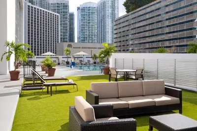 a rooftop patio with a couch and tables and chairs at Courtyard Miami Downtown Brickell Area in Miami