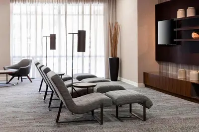 a lobby with a row of chairs and a television at Courtyard by Marriott Miami at Dolphin Mall in Miami