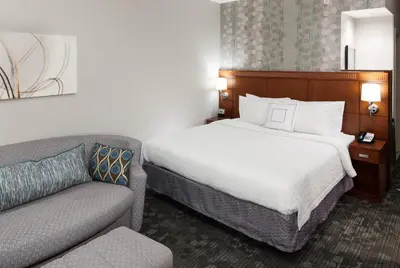 a hotel room with a bed and a couch at Courtyard by Marriott Miami at Dolphin Mall in Miami