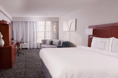 a hotel room with a large bed and a couch at Courtyard Miami Coral Gables in Miami