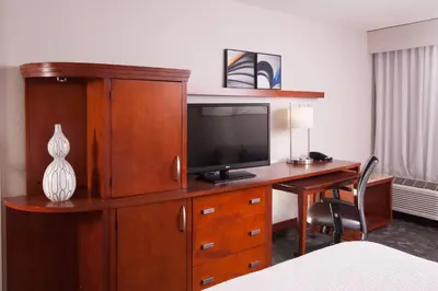 a hotel room with a desk with a television on it at Courtyard Miami Coral Gables in Miami