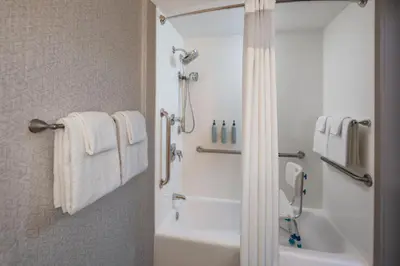 a bathroom with a tub and a shower with towels at Courtyard Miami Coral Gables in Miami