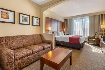 a hotel room with a couch and a bed at Comfort Suites Miami - Kendall in Kendall
