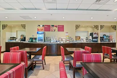 a restaurant with tables and chairs and a counter at Comfort Suites Miami - Kendall in Kendall