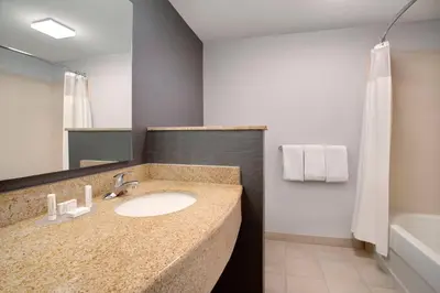 a bathroom with a sink and a mirror and a tub at Courtyard Fort Lauderdale SW Miramar in Miramar