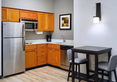 a kitchen with a stainless steel refrigerator and a table at Residence Inn Fort Lauderdale SW/Miramar in Miramar
