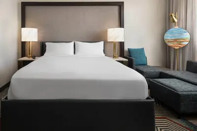 a bedroom with a large white bed and a chair at Renaissance Fort Lauderdale West Hotel in Plantation