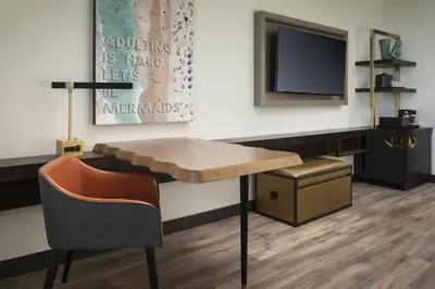 a waiting room with a table and a tv at Renaissance Fort Lauderdale West Hotel in Plantation