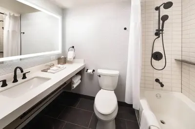 a bathroom with a toilet and a tub and a sink at Renaissance Fort Lauderdale West Hotel in Plantation