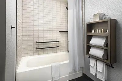 a bathroom with a tub and a shower with towels at Renaissance Fort Lauderdale West Hotel in Plantation
