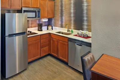 a kitchen with wooden cabinets and a stainless steel refrigerator at Residence Inn by Marriott Fort Lauderdale Weston in Weston