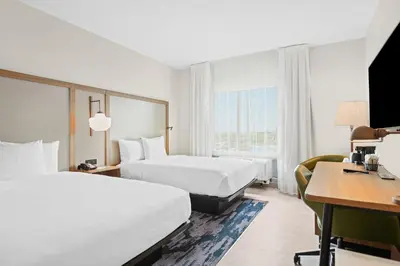 a hotel room with two beds and a desk at Fairfield Inn & Suites Fort Lauderdale Airport & Cruise Port in Dania Beach