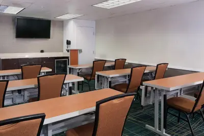 a classroom with tables and chairs and a flat screen tv at SpringHill Suites Fort Lauderdale Airport in Dania Beach