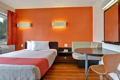 a hotel room with a bed and a table at Motel 6 Dania Beach in Dania Beach