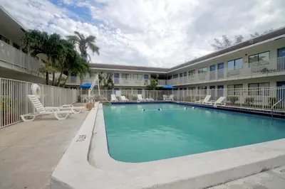 a swimming pool in front of a building at Motel 6 Dania Beach in Dania Beach