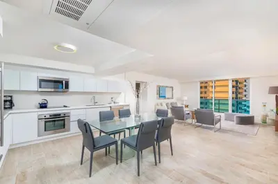 a kitchen and dining room with a glass table and chairs at Oceanfront Private Condo at 1 Hotel & Homes -1019 in Miami Beach