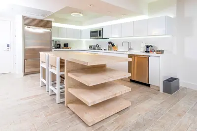 a kitchen with white cabinets and a wooden counter top at Oceanview Private Condo at 1 Hotel & Homes -1106 in Miami Beach