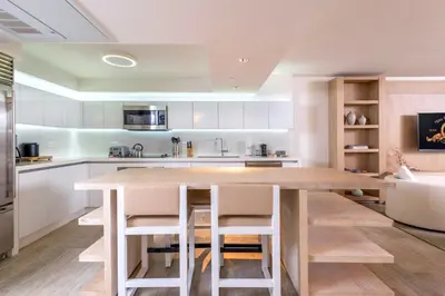 a kitchen with a wooden table and white cabinets at Oceanview Private Condo at 1 Hotel & Homes -1106 in Miami Beach